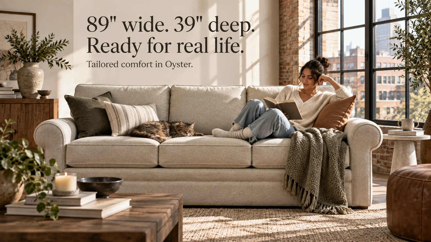 Campaign banner: woman reading on the Collins sofa with a cat — "89in wide. 39in deep. Ready for real life. Tailored comfort in Oyster."