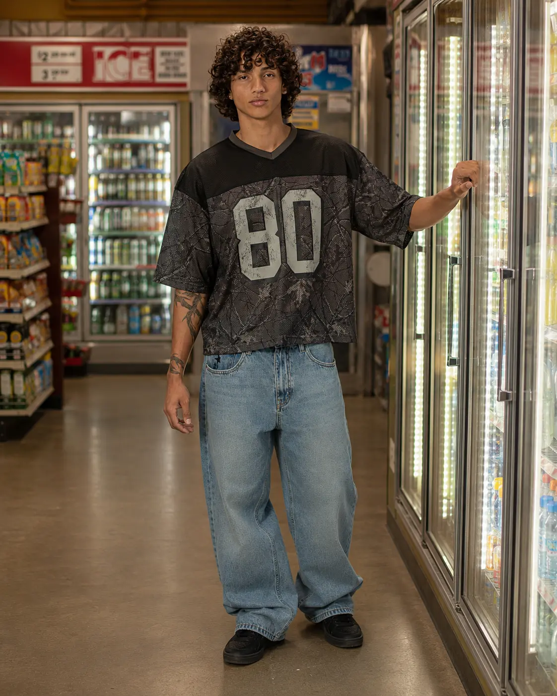 Man in a mesh jersey by the coolers in a convenience store