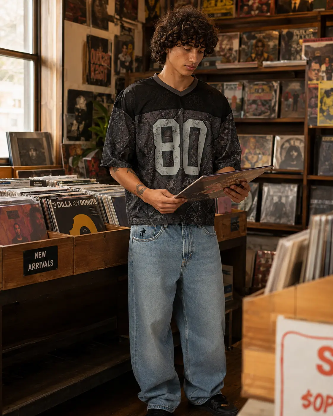 Man in a mesh jersey browsing vinyl in a record store