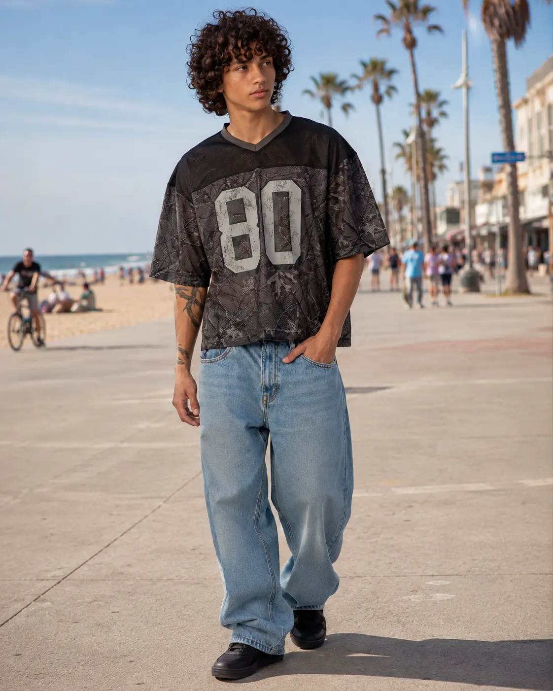 Man in a mesh jersey walking a beachfront boardwalk
