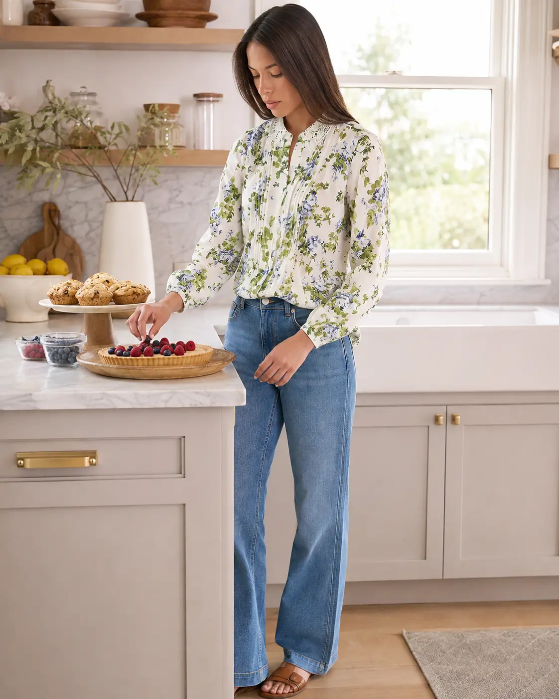 Model in a floral pintuck blouse in a bright kitchen